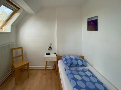 a bedroom with a bed and a desk and a window at Apartment in Bergen aan Zee near Beach in Bergen aan Zee