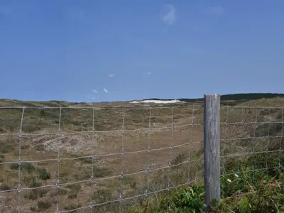 a fence in the middle of a field at Dune Top Family Retreat in Bergen aan Zee