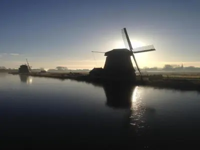 a windmill in the middle of a body of water at Dune Top Family Retreat in Bergen aan Zee