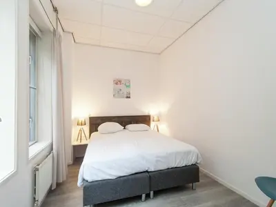 a white bedroom with a bed with two pillows at Dune Top Family Retreat in Bergen aan Zee