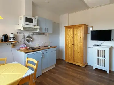 a small kitchen with a sink and a microwave at Apartment in Bergen near the Beach in Bergen aan Zee
