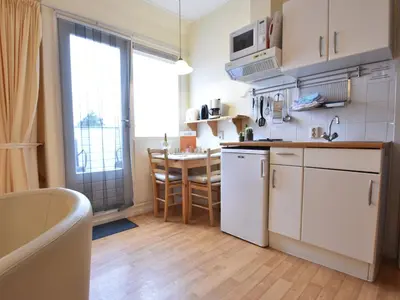 a kitchen with white cabinets and a table and a tub at Apartment in Bergen near the Beach in Bergen aan Zee