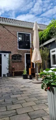 an umbrella sitting on a patio in front of a house at Beautiful loft in Katwijk aan Zee in Katwijk aan Zee
