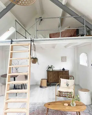 a room with a bunk bed and a chair and a table at Beautiful loft in Katwijk aan Zee in Katwijk aan Zee