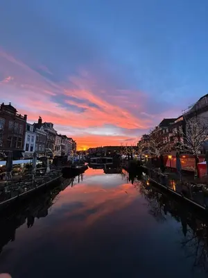 a view of a river with buildings and a sunset at Beautiful loft in Katwijk aan Zee in Katwijk aan Zee