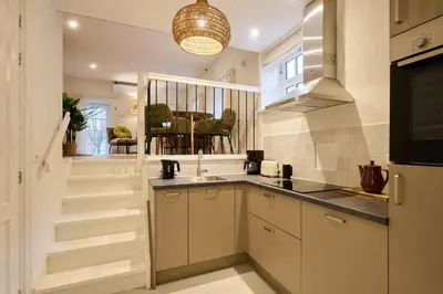 a kitchen with white cabinets and a sink at Appartement B Rosita in Twisk