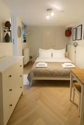 a bedroom with a large bed and a desk at Tiny House Bliss in Amsterdam