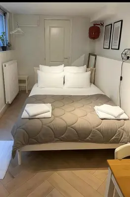 a large bed with two pillows on it in a room at Tiny House Bliss in Amsterdam