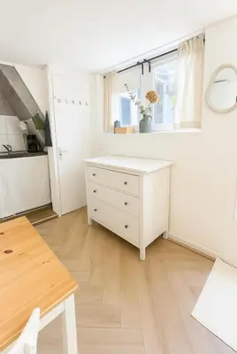 a white kitchen with a desk and a window at Tiny House Bliss in Amsterdam