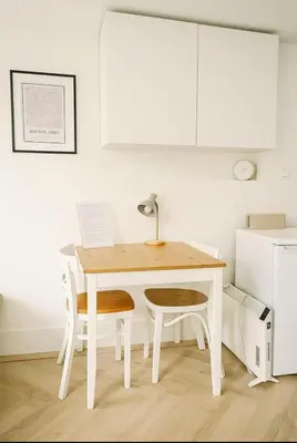 a white kitchen with a table and two chairs at Tiny House Bliss in Amsterdam