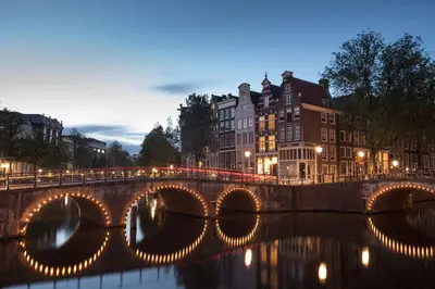 a bridge over a river in front of a building at Tiny House Bliss in Amsterdam