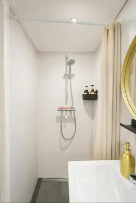 a white bathroom with a sink and a mirror at Tiny House Bliss in Amsterdam