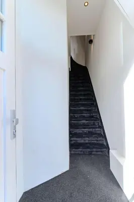 a staircase in a white building with a stair case at Haarlem Hart in Haarlem