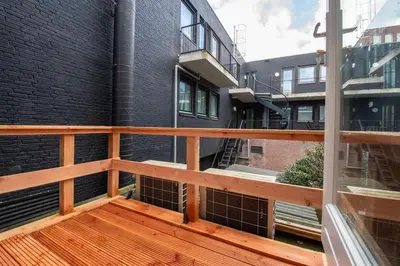 a balcony with a wooden railing next to a building at Haarlem Hart in Haarlem