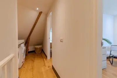 a hallway with a stairway leading to a room at Haarlem Hart in Haarlem
