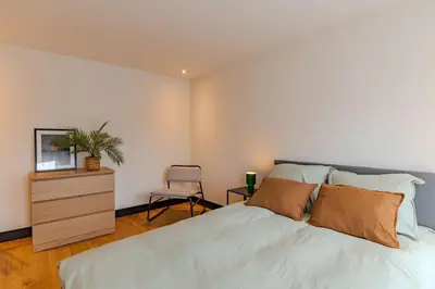 a bedroom with a large bed and a chair at Haarlem Hart in Haarlem