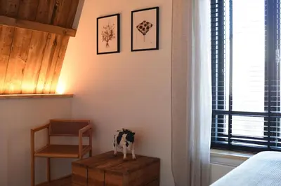 a bedroom with a cow statue on a wooden box at Het Binnenhuys, Luxe B&B in Noordwijk met tuin, vlakbij het strand in Noordwijk