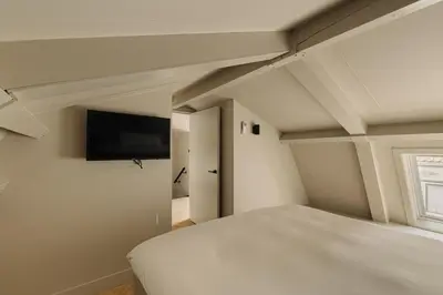 a bedroom with a bed and a flat screen tv at De Ooievaar in Naarden