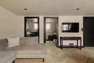 a living room with a couch and a flat screen tv at De Ooievaar in Naarden