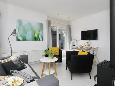 a living room with a couch and a table at Holiday Home Zonneschijn by Interhome in Noordwijkerhout