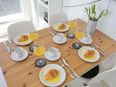 a table with plates of food and glasses of orange juice at Holiday Home Zonneschijn by Interhome in Noordwijkerhout