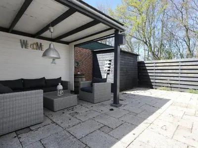 a patio with awning and a couch and chairs at Holiday Home Zonneschijn by Interhome in Noordwijkerhout