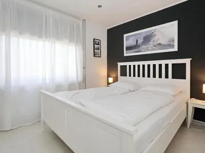 a white bed in a bedroom with a black wall at Holiday Home Zonneschijn by Interhome in Noordwijkerhout