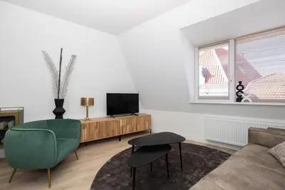 a living room with a couch and a television at Hoorn Center - Dashing Hoorn in Hoorn