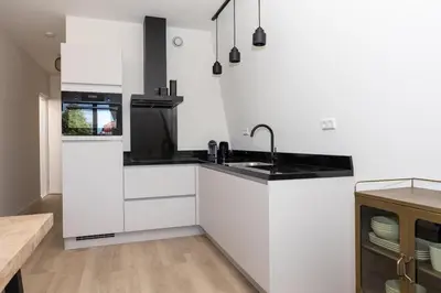 a white kitchen with a sink and a stove at Hoorn Center - Dashing Hoorn in Hoorn