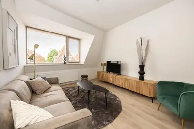 a living room with a couch and a tv at Hoorn Centre - Catching Hoorn in Hoorn