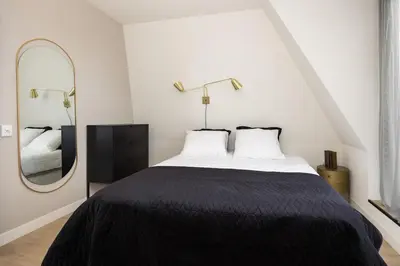 a bedroom with a large bed and a mirror at Hoorn Centre - Catching Hoorn in Hoorn