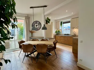 a kitchen and dining room with a table and chairs at Vakantiehuis Pollux 6 pers 300m van het strand in Noordwijk aan Zee