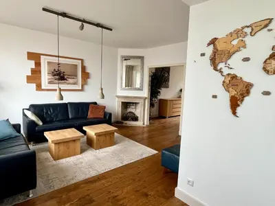 a living room with a couch and a world map on the wall at Vakantiehuis Pollux 6 pers 300m van het strand in Noordwijk aan Zee