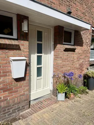 a front door of a brick house with flowers at Vakantiehuis Pollux 6 pers 300m van het strand in Noordwijk aan Zee