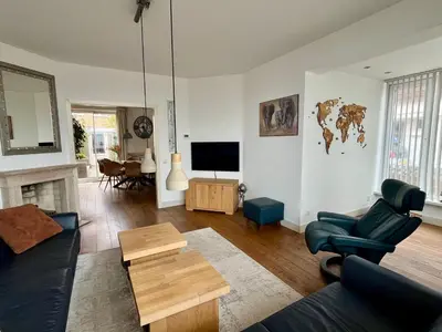 a living room with a couch and a tv at Vakantiehuis Pollux 6 pers 300m van het strand in Noordwijk aan Zee