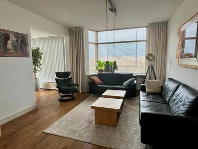 a living room with a couch and a table at Vakantiehuis Pollux 6 pers 300m van het strand in Noordwijk aan Zee