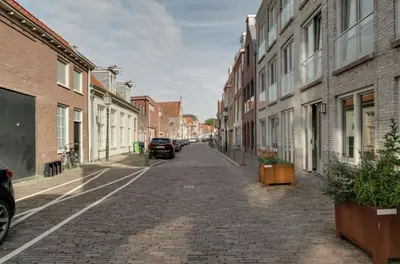 an empty street with buildings and cars on the street at Serviced Accommodation Hoorn - Corporate Housing NN38 in Hoorn