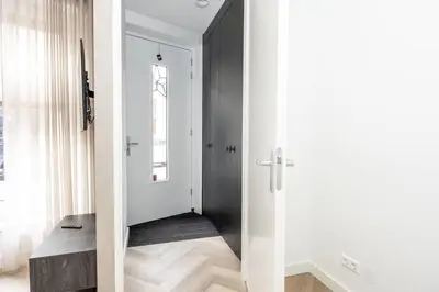 a hallway with white walls and a black door at Serviced Accommodation Hoorn - Corporate Housing NN38 in Hoorn