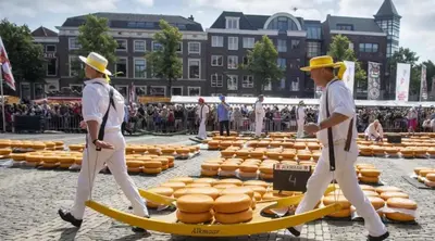 two men walking past a bunch of hot dogs on surfboards at Houseboat Uitgeest in Uitgeest