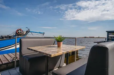 a wooden table on the back of a boat at Houseboat Uitgeest in Uitgeest