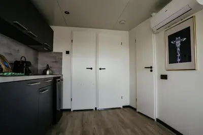 a kitchen with white cabinets and a counter top at Houseboat Plus Uitgeest in Uitgeest