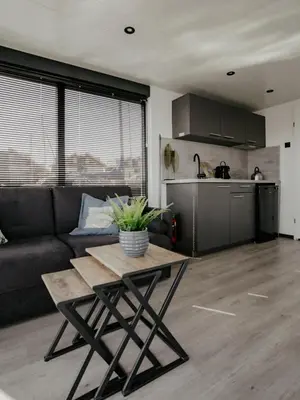a living room with a couch and a table at Houseboat Plus Uitgeest in Uitgeest