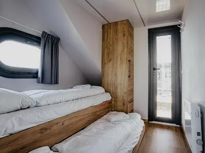 a room with three beds on the wall at Houseboat Campi Uitgeest in Uitgeest
