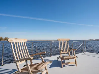 two rocking chairs sitting on the deck of a boat at Houseboat Campi Uitgeest in Uitgeest