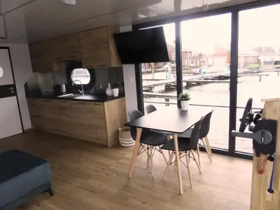 a kitchen and dining room with a table and chairs at Houseboat Campi Uitgeest in Uitgeest