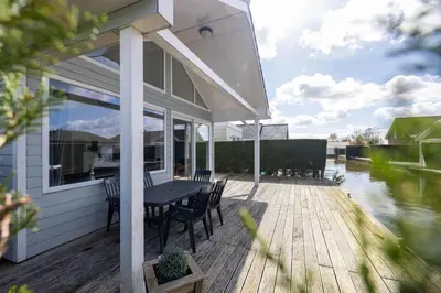 a patio with a table and chairs on a deck at Wilgenroos 6P - Lijsterlaan 198 in Wervershoof