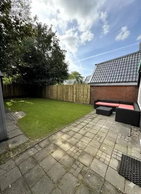 a patio with two benches in a yard at 3 bedrooms Family House till 6 p Near Amsterdam & Sea in Opmeer