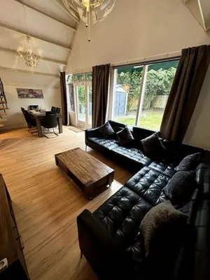 a living room with a leather couch and a coffee table at 3 bedrooms Family House till 6 p Near Amsterdam & Sea in Opmeer