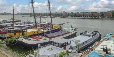 a group of boats docked in a harbor at Near Amsterdam central station in Amsterdam