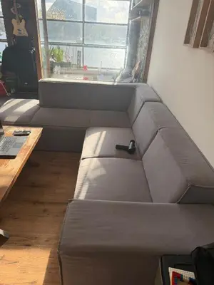 a couch with a remote control on it in a room at Near Amsterdam central station in Amsterdam